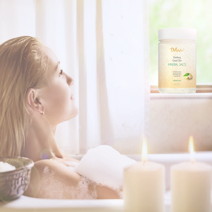 Woman relaxing in a bathtub with a jar of Deluvia Dead Sea Mineral Salts Unscented in the background