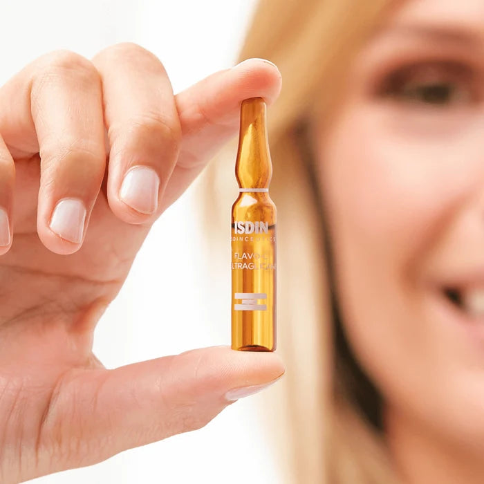ISDIN Flavo-C Ultraglican vitamin C ampoule held between fingers