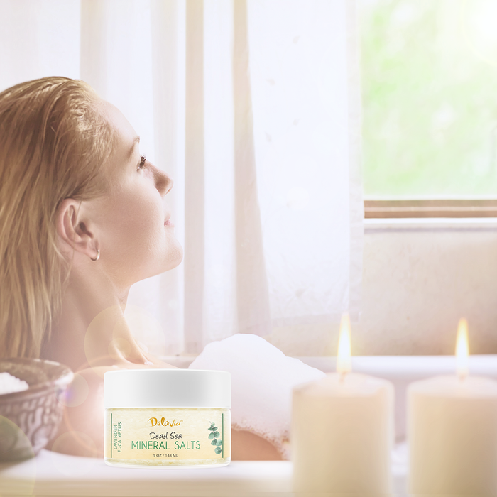 Woman soaking in a bathtub with Deluvia Dead Sea minerals in the foreground.