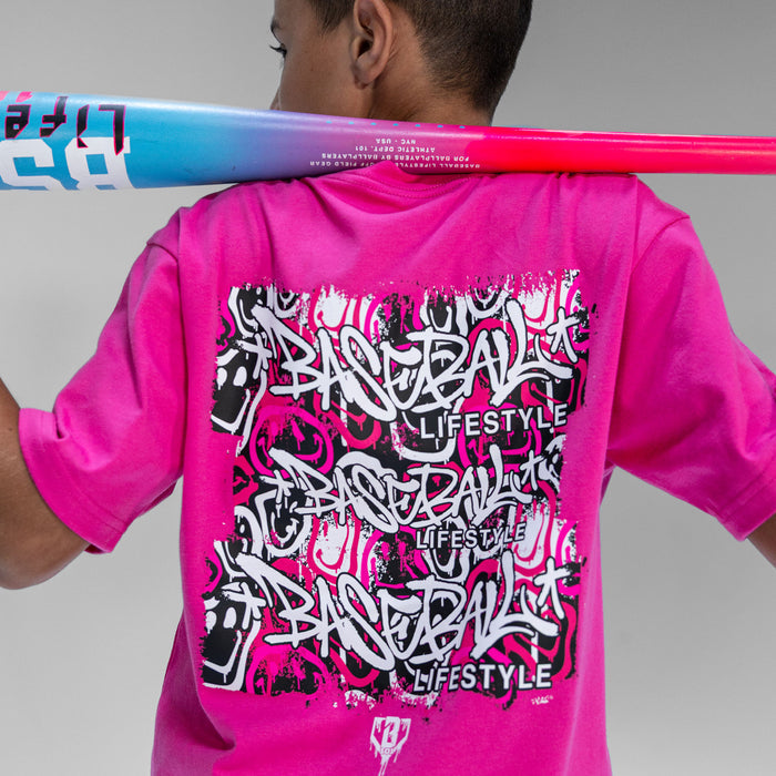 Person wearing a pink 'Baseball Lifestyle' shirt with graffiti graphics and a colorful bat over their shoulder.