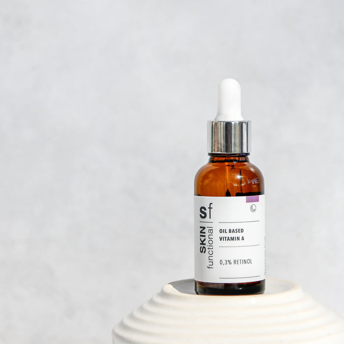 Brown glass dropper 0,3% Retinol Oil Serum bottle with a white label on a light gray background