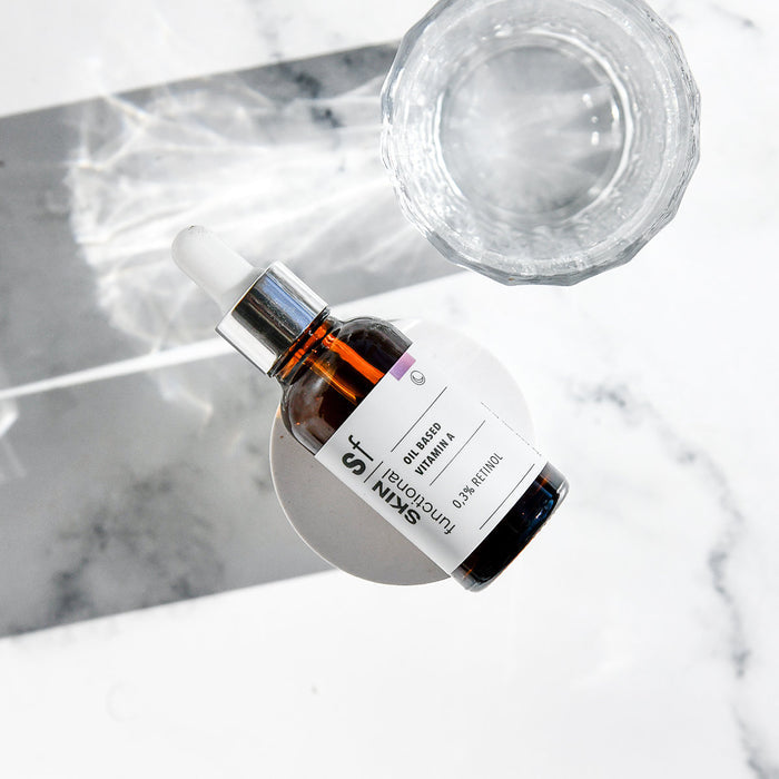 0,3% Retinol Oil Serum Skincare serum bottle with dropper on a marble surface