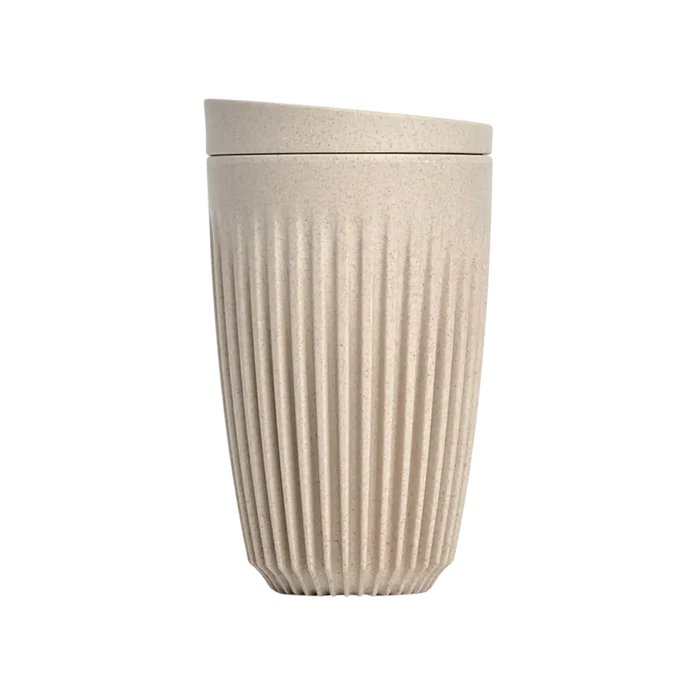 Beige textured tumbler with lid on a white background