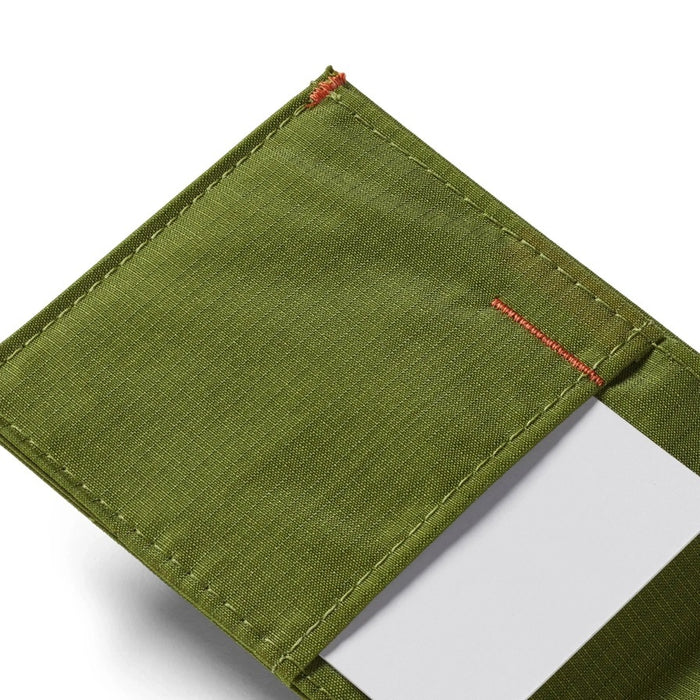 A close-up of the ALLETT Sport Wallet in Cala Green shows its green RFID-blocking ripstop nylon, visible stitching, and a white card partially tucked into one pocket.