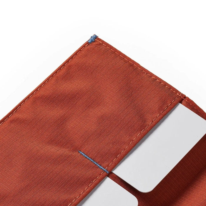 An ultra-slim, closed ALLETT wallet in RFID-blocking Potter’s Clay nylon, featuring a small gray or light blue "A" logo on the bottom right, shown on a white background.