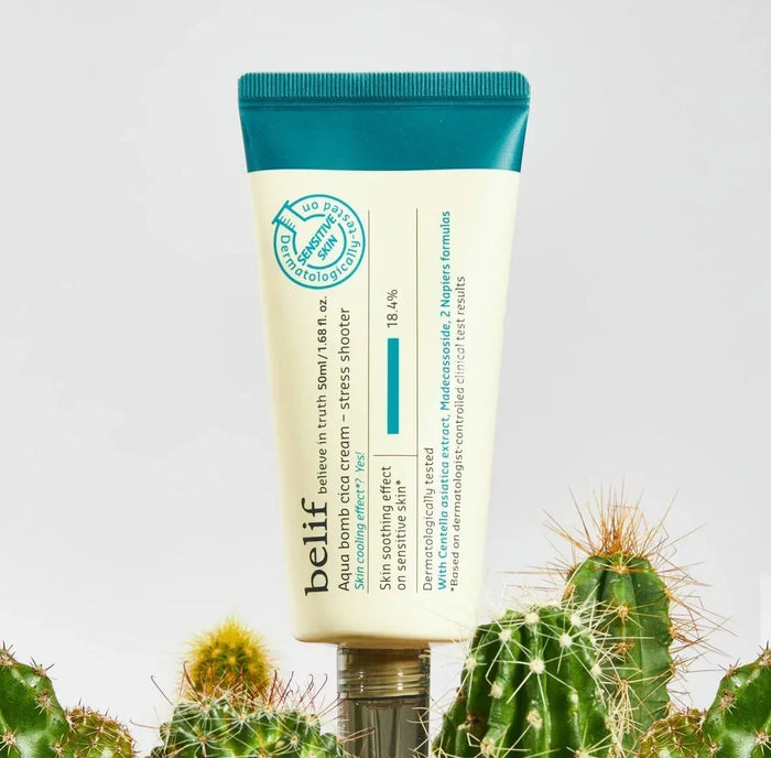 Aqua bomb cica cream tube for sensitive skin with teal cap standing among green cacti.