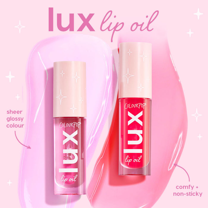 ColourPop Lux Lip Oil Bengal standing upright with another tube, showing pink and fuchsia swatches, star-stamped blush caps and bold lux logo, highlighting a sheer glossy, comfy, non-sticky finish on a pastel pink backdrop.