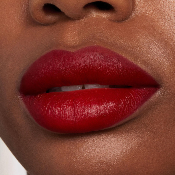 Bold lips wearing ColourPop Bichette Lippie Stix in deep cherry red, showing full-coverage matte finish with crisp edges; tight studio close-up highlighting rich pigment and lip texture on natural skin.