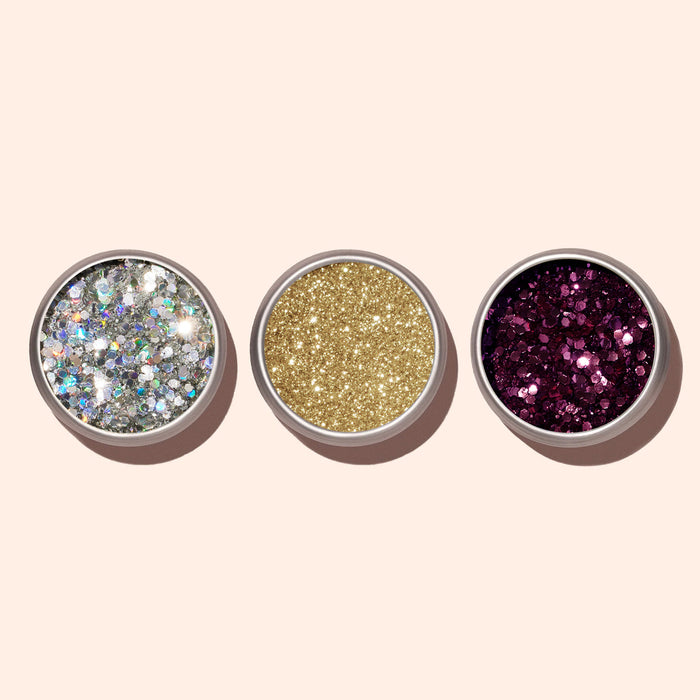 Three round containers of Manucurist Biodegradable Holo Glitter in silver holographic, gold, and magenta are arranged in a row on a light background—perfect eco-friendly sparkles for your next manicure.