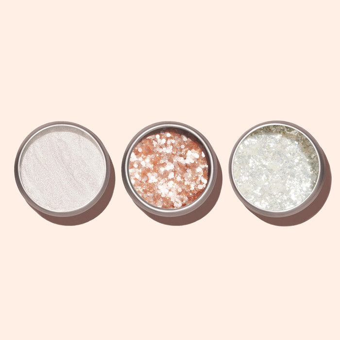 Three round containers of Manucurist Blush Biodegradable Glitter—white, pale pink with chunky sparkle for nail art, and silver with fine eco-friendly glitter—are arranged side by side on a pale background.