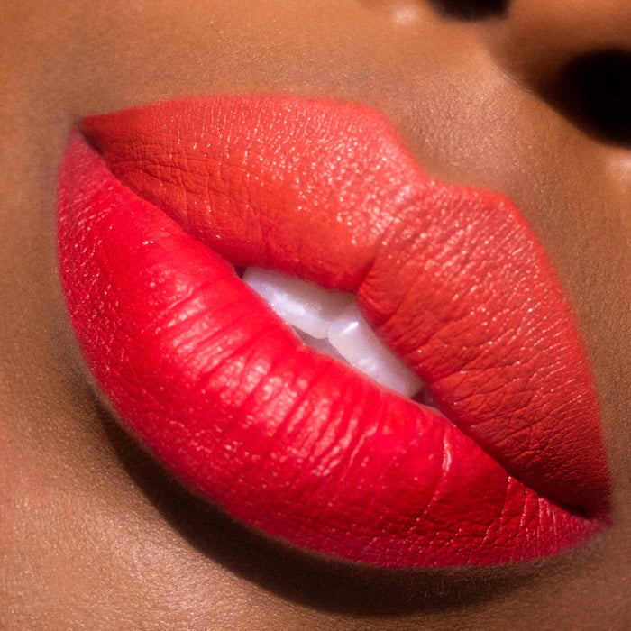 Bold ombré red-to-orange lips lined and filled with ColourPop Bring The Heat Lippie Pencil, lips slightly parted to show teeth, crisp edges and creamy matte payoff in a tight beauty close-up.