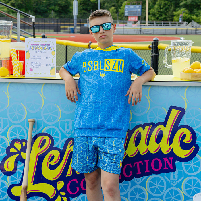 Youth model wearing blue youth short sleeve hoodie with "BSBL-SZN V3" design