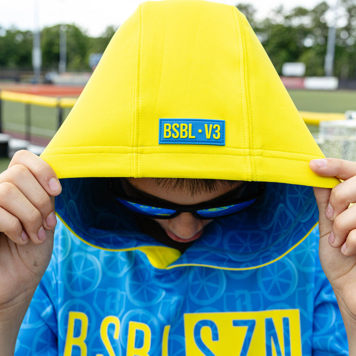 Youth model wearing blue youth short sleeve hoodie with "BSBL-SZN V3" design