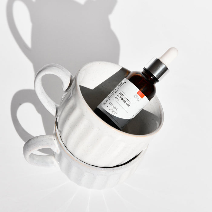SKIN Functional dark circles, puffiness and lines treatment with details skincare product on a grey background