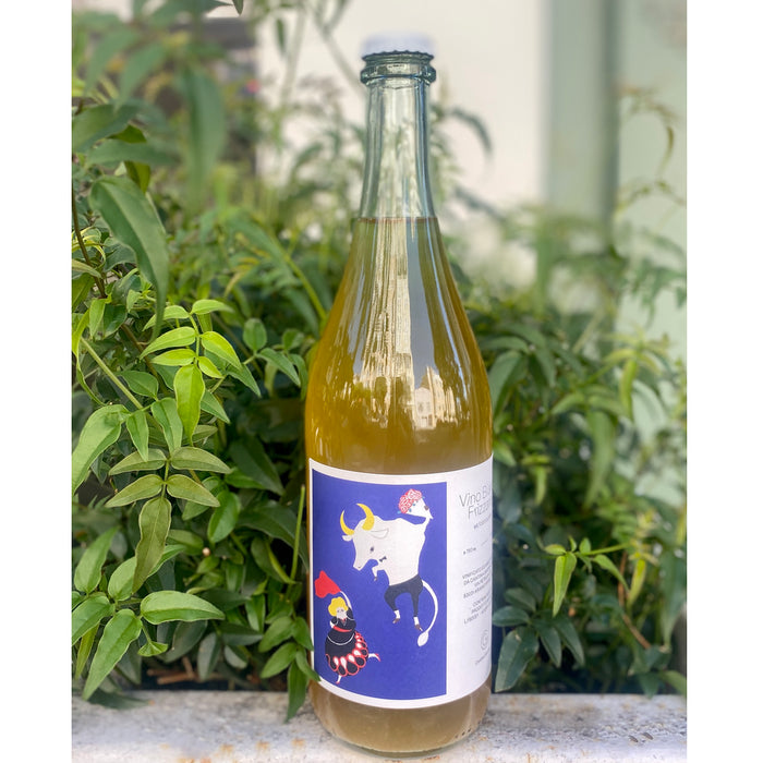 Sparkling white wine bottle with amber glass and blue label featuring a dog illustration