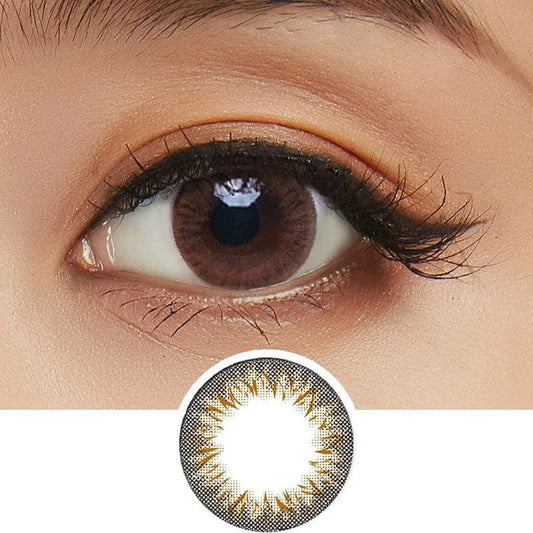 A close-up of a brown eye with long lashes wearing Clalen Iris Latin Brown (30pk) lenses by Clalen, featuring a subtle brown and gold starburst pattern. An enlarged image of the lens design appears below the eye.