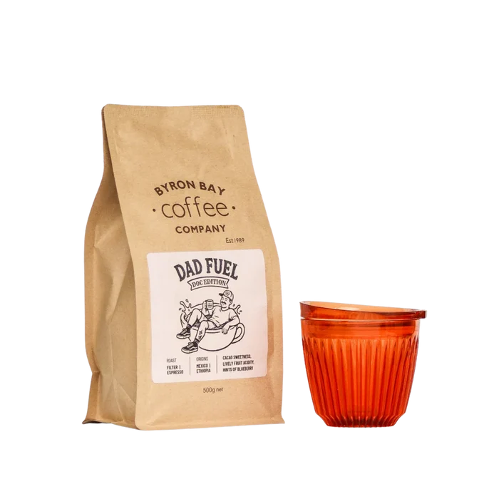 A 500g bag of Dad Fuel coffee next to an Amber Huskee Coffee Cup
