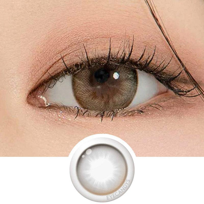 Macro shot of an eye wearing the DooNoon Glam 1-Day Grey (10pk) prescription colour contact lens, showing the multi-colored detail and natural effect on dark brown eyes, with clean eye makeup. At the bottom is the pattern of the colored lens design, showing the dotted detail and pigmentation.