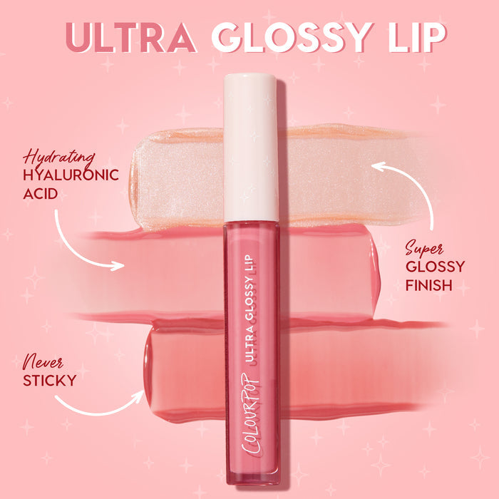 ColourPop Ultra Glossy Lip tube from the Dream Duo Ultra Lip Duo rests over pearly nude and rosy pink swatches, showcasing hydrating hyaluronic acid with a super glossy, never-sticky finish on a pink backdrop; ColourPop Ultra Lip Duo.