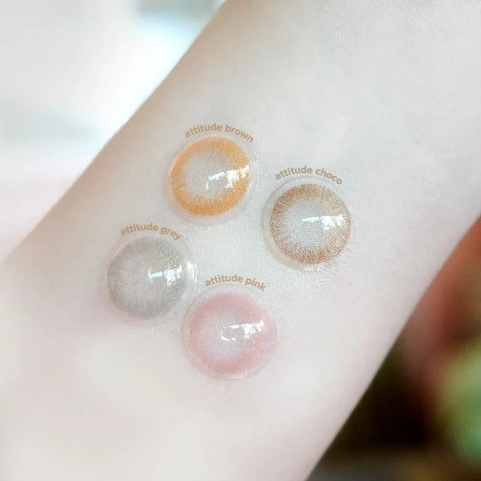 EyeCandys Attitude Glitter Brown contact lenses by EyeCandys are shown on the back of a hand, highlighting their stylish translucent design and unique brown shade for a natural, fashionable look.