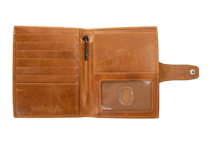 The GARZINI RFID-blocking leather passport holder in cognac features an AirTag compartment and opens to reveal card slots, a pen, and a burgundy passport—combining security with elegant organization.