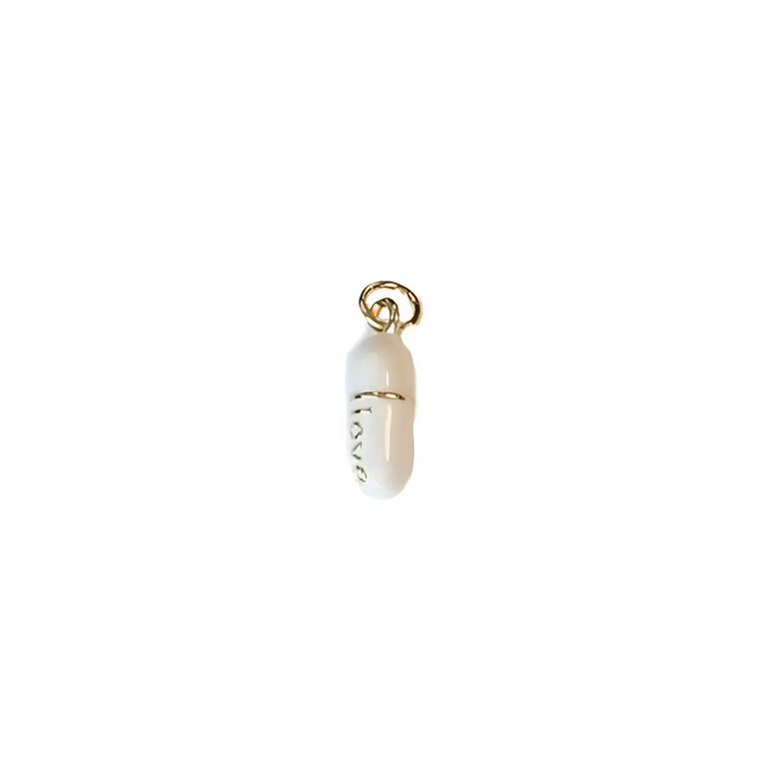 White pill charm with gold-tone ring bail and love engraving on side