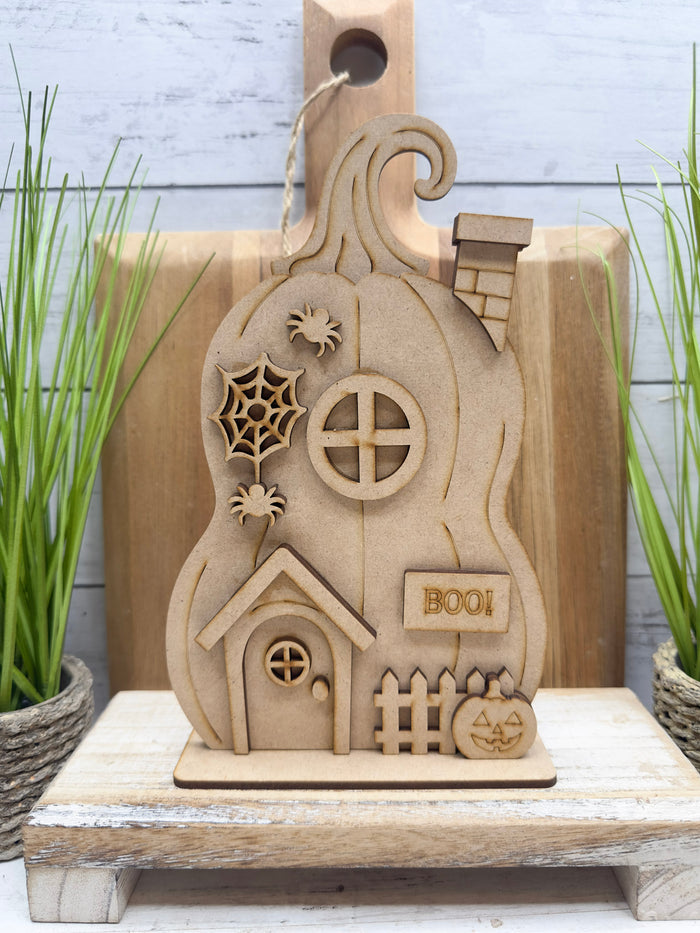 Unfinished Haunted Pumpkin House DIY Kit assembled on a standing base with layered Halloween details