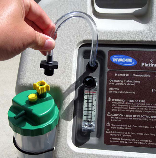 Hand connecting a green and yellow device to an Invacare Platinum machine.