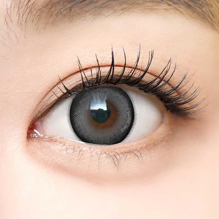Close-up shot of a model with natural dark eyes wearing Dekame Look At Me Grey contact lenses, complemented by natural eye make up.