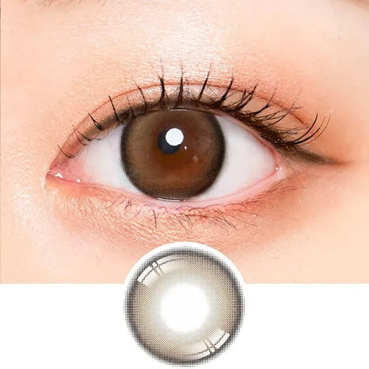 Macro shot of an eye wearing the i-Sha Oriana Mune Brown prescription colour contact lens, showing the multi-colored detail and natural effect on dark brown eyes, with clean eye makeup. At the bottom is the pattern of the colored lens design, showing the dotted detail and pigmentation.