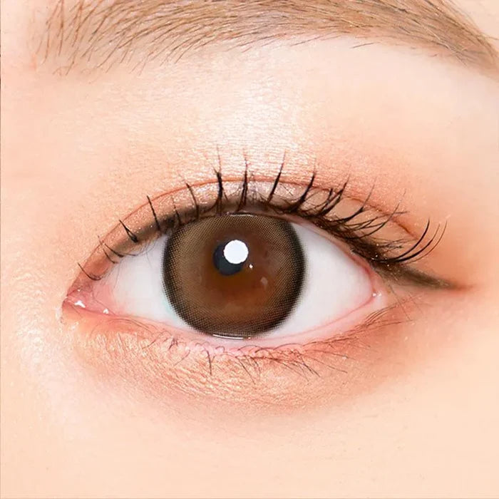 Macro shot of an eye wearing the i-Sha Oriana Mune Brown prescription colour contact lens, showing the multi-colored detail and natural effect on dark brown eyes.