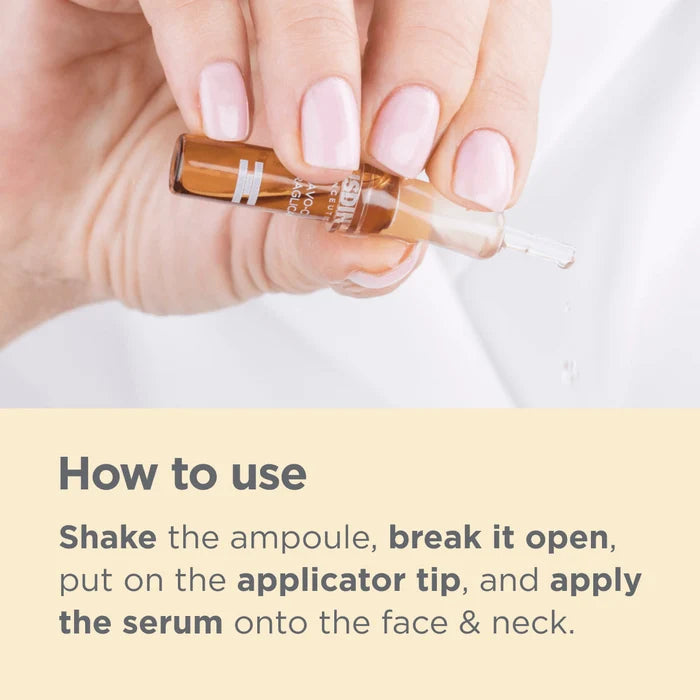 Hand holding ISDIN Flavo-C Ultraglican ampoule with applicator tip