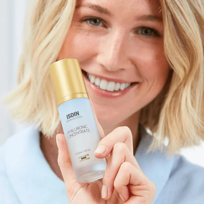 Woman holding ISDIN Isdinceutics Hyaluronic Concentrate serum bottle