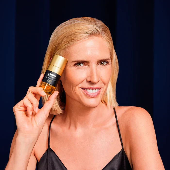 Blonde woman holding ISDIN Isdinceutics Retinal Eyes serum bottle
