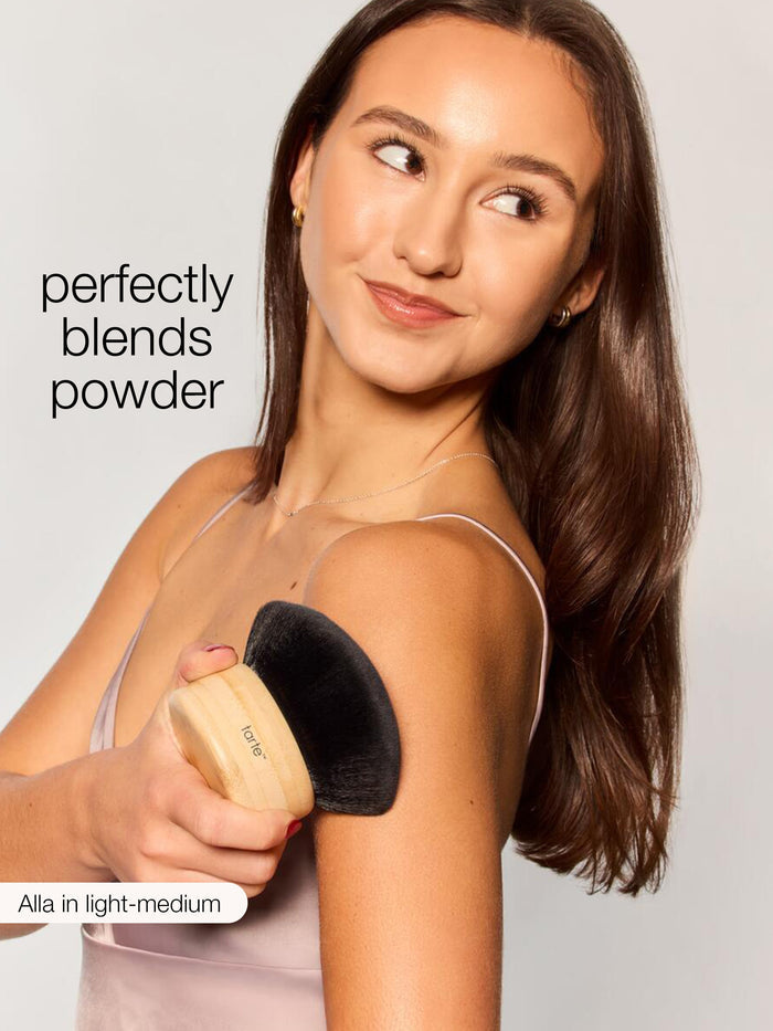 Woman applying sunscreen with a brush, emphasizing streak-free application.