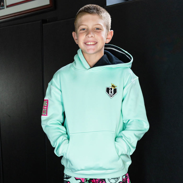 Youth model wearing teal hoodie with "King Of JUCO" design
