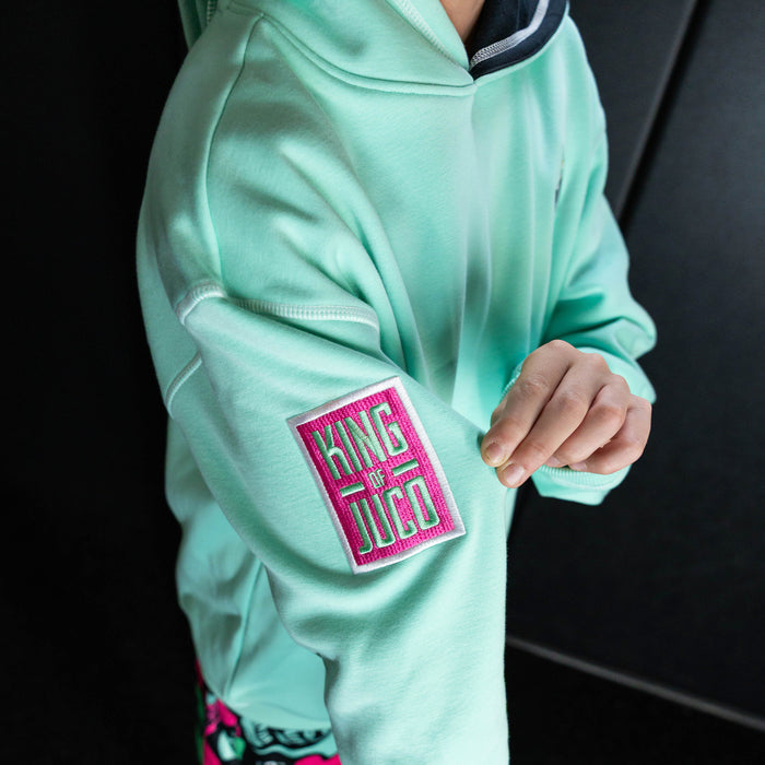 Youth model wearing teal hoodie with "King Of JUCO" design