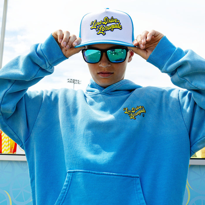 Youth model wearing blue youth hoodie with "Lemonade Cup" design
