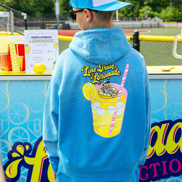 Youth model wearing blue youth hoodie with "Lemonade Cup" design