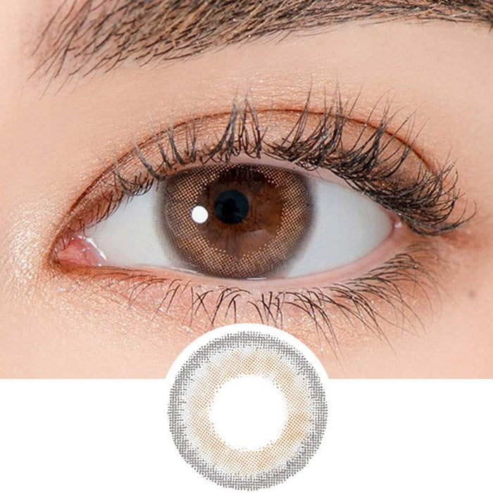 Close-up shot of a model's eye wearing Lensrang Celinay Grey color contacts with prescription, paired with K-beauty-inspired eye makeup, showing the brightening and enlarging effect of the circle contact lens on dark brown eyes, above a cutout of the contact lens pattern with limbal ring on a white background.