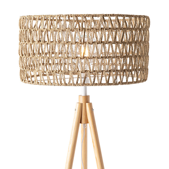 The Lexi Seagrass Natural Tripod Floor Lamp (165x45cm) features a woven rattan shade and wooden legs, capturing the relaxed charm of coastal living. Shown against a white background.