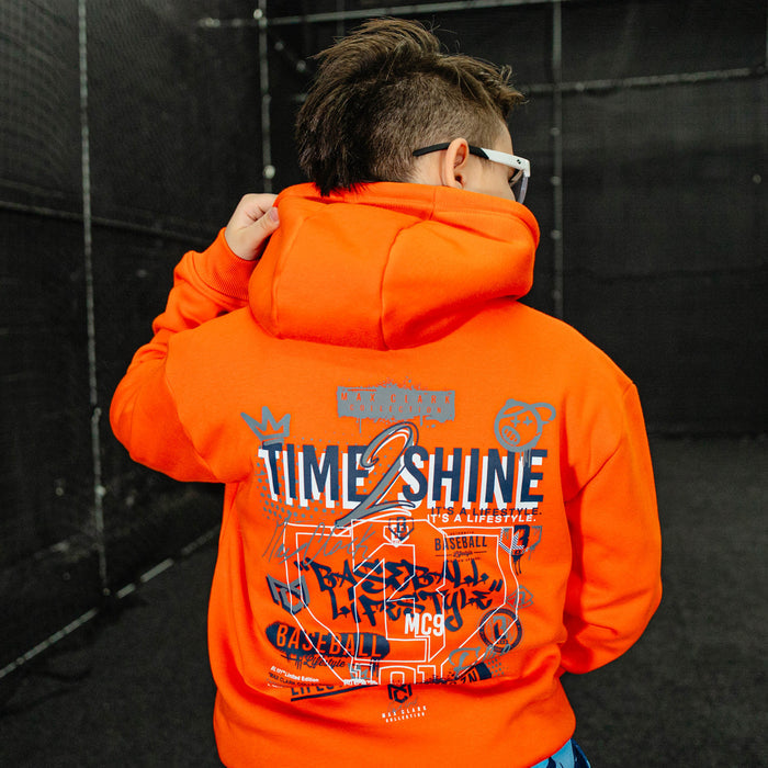 Youth model wearing orange Max Clark youth hoodie