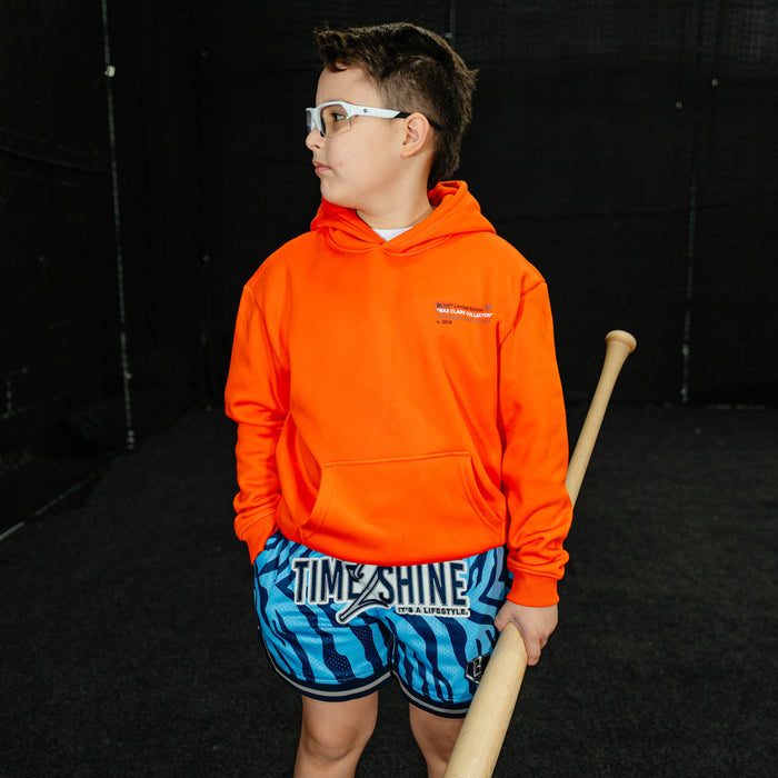 Youth model wearing orange Max Clark youth hoodie