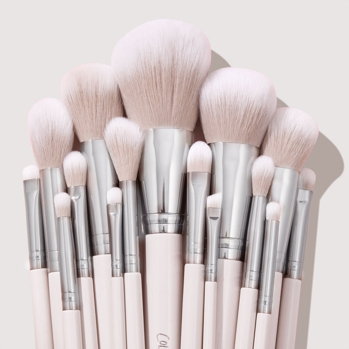 Metallic Mood brushes fan out in a tight cluster, showcasing soft blush-pink bristles, chrome ferrules, and pale pink handles on a light backdrop - part of the ColourPop Shadow Palette & Brush Set for precise eye and face makeup.