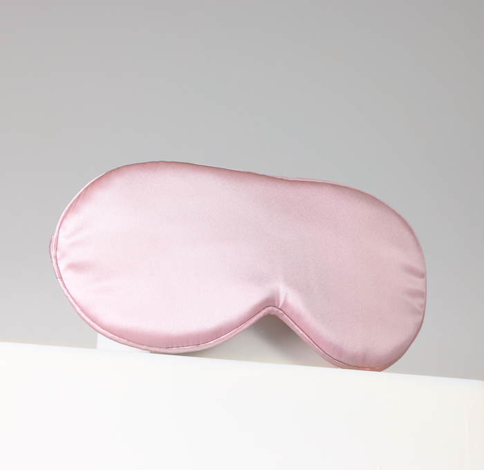 Pink sleep mask on a light gray background