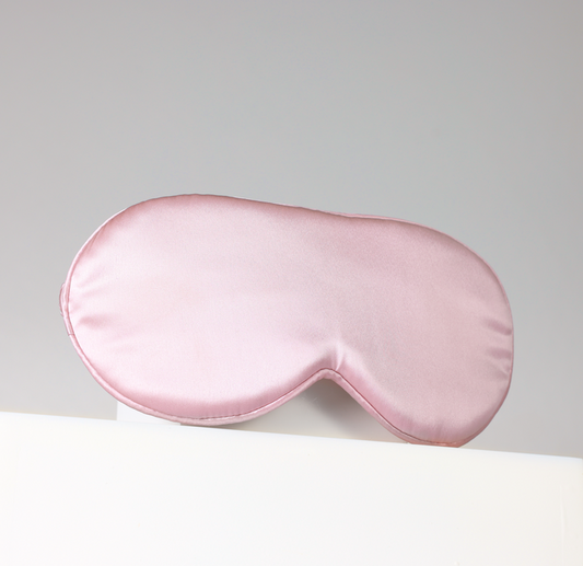 Pink sleep mask on a light gray background