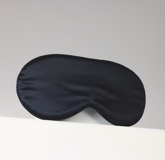 Black sleep mask on a light gray background