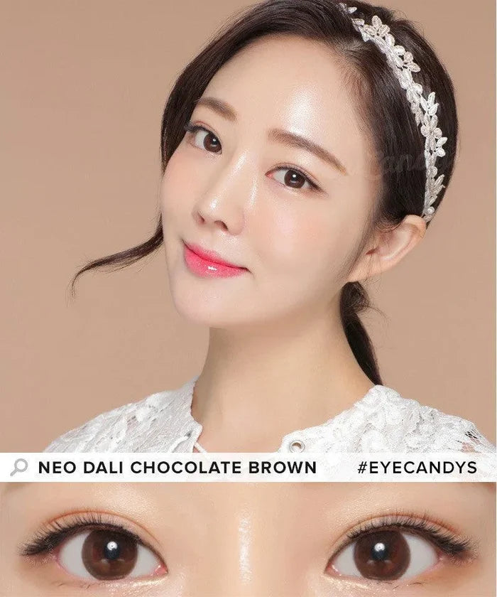 A woman with smooth, glowing skin and glossy lips wears a white lace headband and top. A close-up shows her brown eyes enhanced by NEO Vision Dali Chocolate Brown lenses by NEO Vision. Text: "NEO VISION DALI CHOCOLATE BROWN #EYECANDYS".