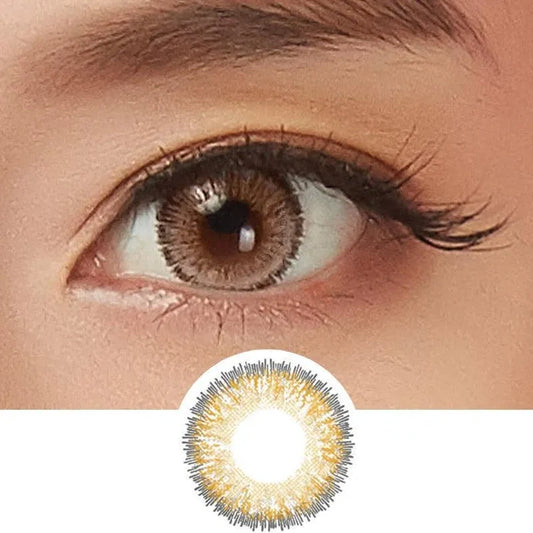 A close-up of a brown eye with long lashes wears NEO Vision Glamour Brown (Custom Toric for Astigmatism) lenses. Below is a detailed image of the lens, displaying a stunning brown and gold radial pattern by NEO Vision.