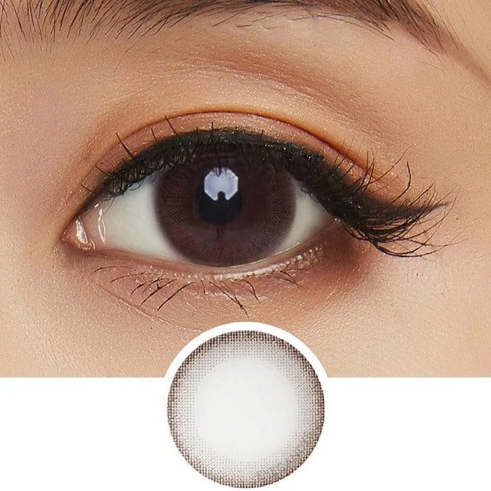 A close-up of a brown eye with long lashes and natural makeup, featuring NEO Vision Monet Brown (Custom Toric for Astigmatism) by NEO Vision—ideal for a natural look with a defined dark outer ring.
